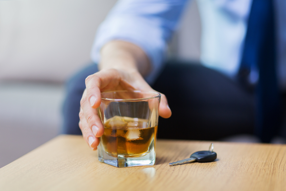 a man reaching for a drink near his car key