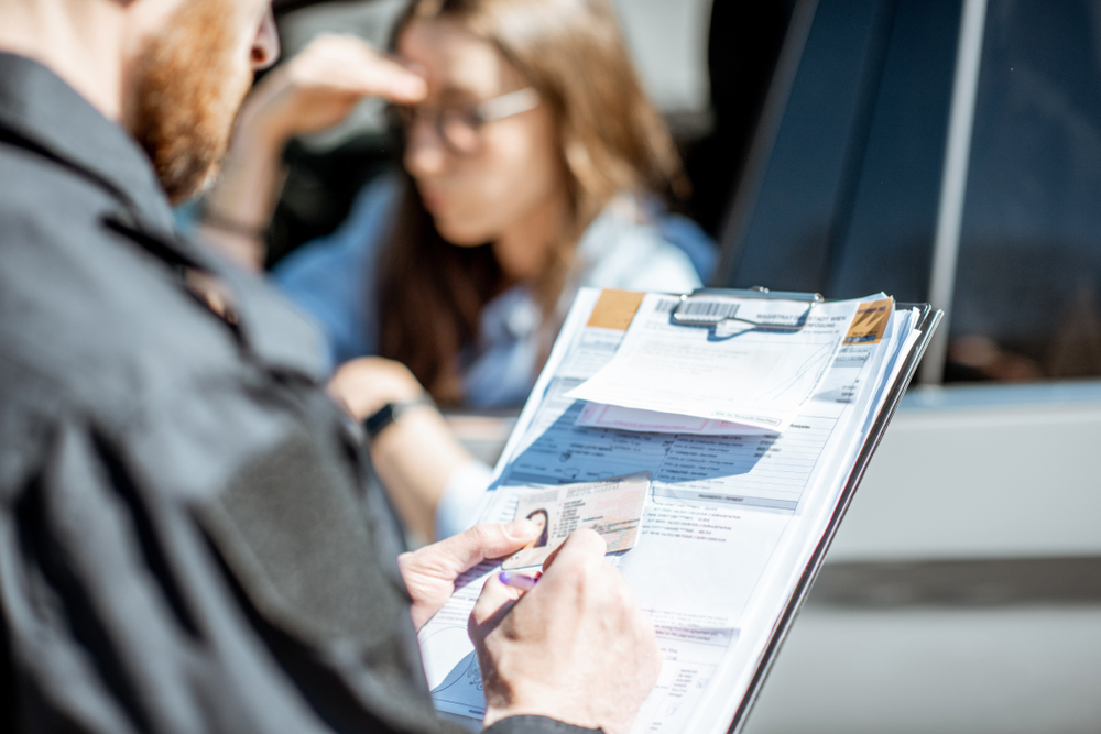 policeman issuing a traffic ticket to a female driver